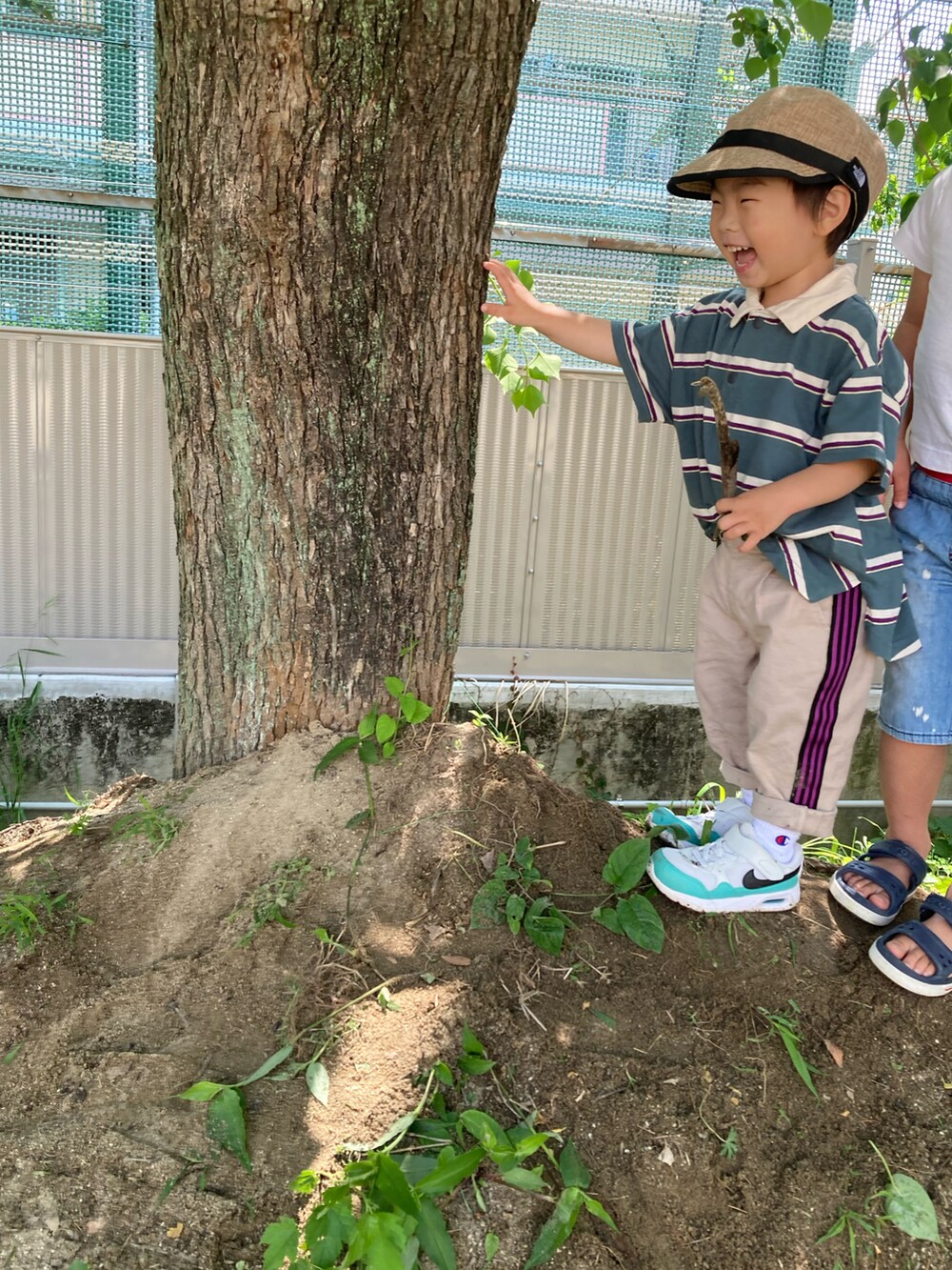 グリーン系のポロシャツ、ベージュ系のその他パンツ、ホワイト系のスニーカーを着用したキッズの春コーディネートの5枚目の写真