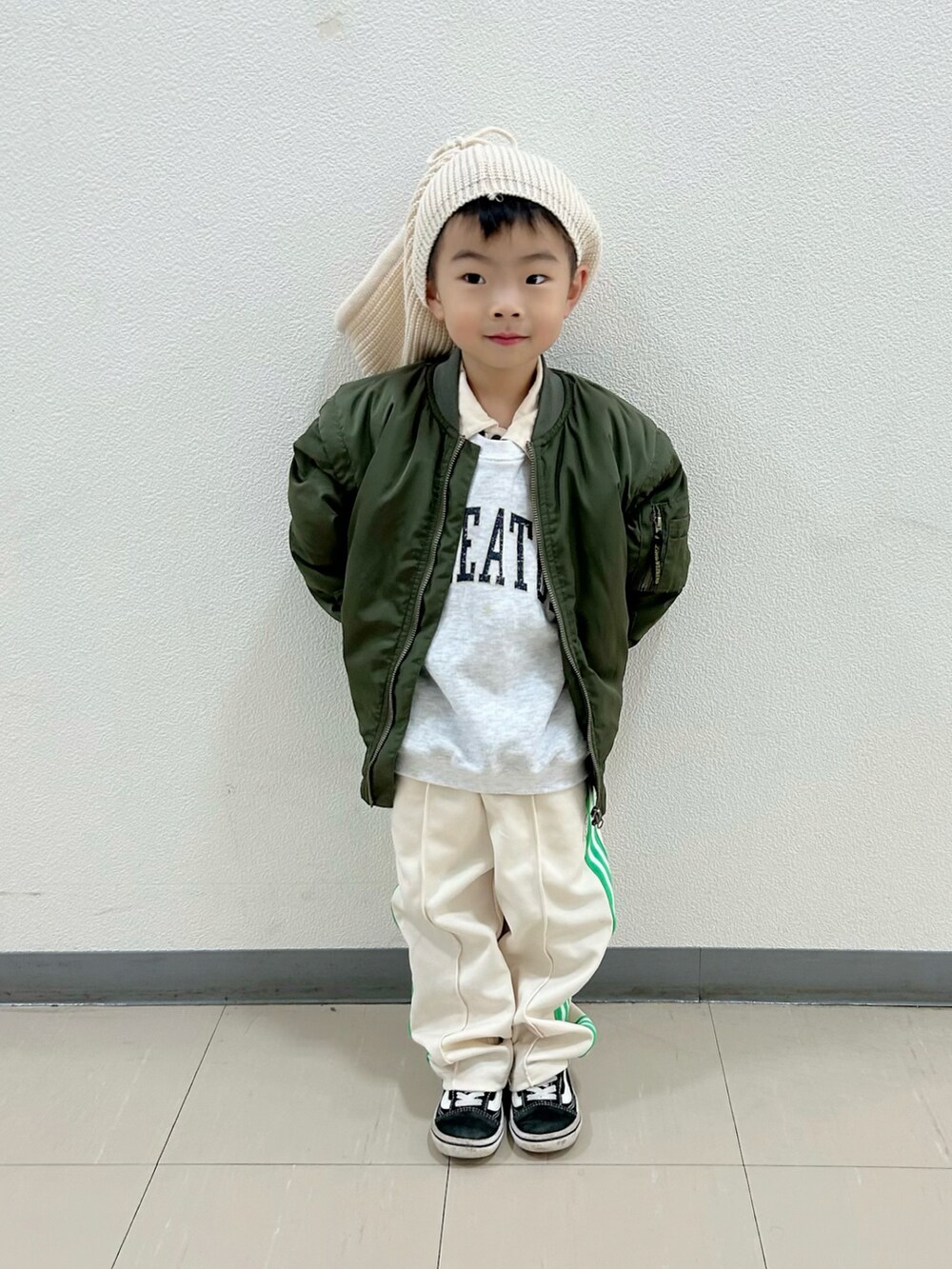 グレー系のスウェット、グリーン系のポロシャツ、グリーン系のMA-1を着用したキッズの秋コーディネートの4枚目の写真