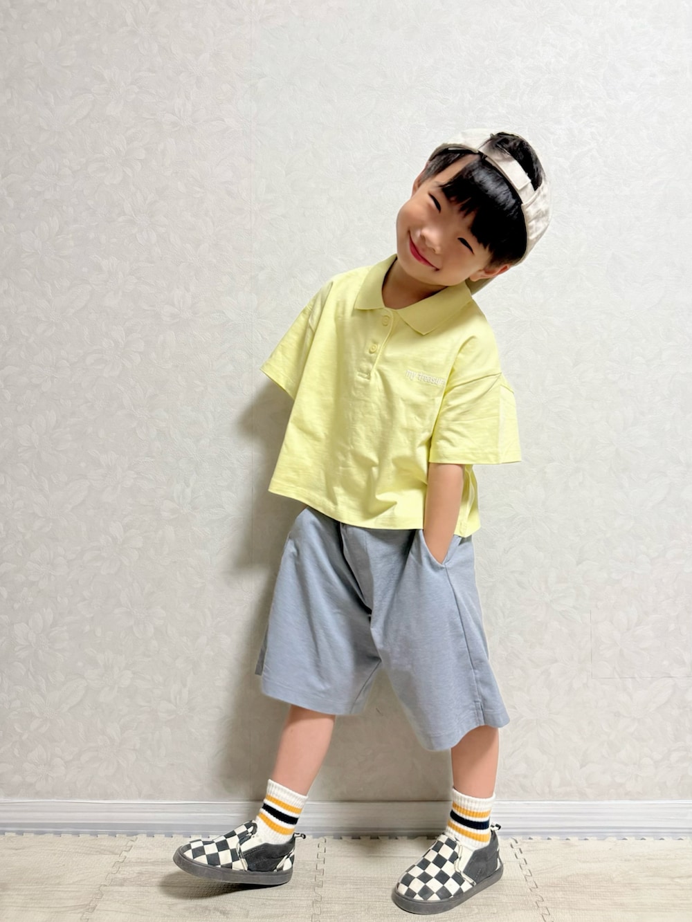 イエロー系のポロシャツ、グレー系のパンツ、その他のスリッポンを着用したキッズの夏コーディネートの3枚目の写真