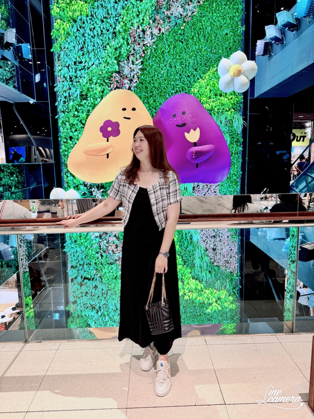 ホワイト系のブルゾン、ブラック系のドラムバッグ、イエロー系のスニーカーを着用したレディースの夏コーディネートの2枚目の写真