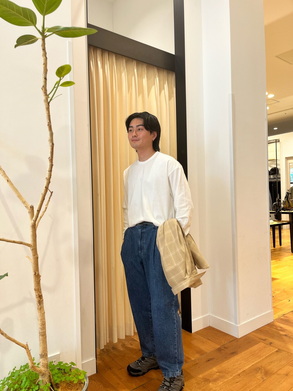 ブルー系のデニムパンツ、グレー系のスニーカーを着用したメンズの秋コーディネートの3枚目の写真