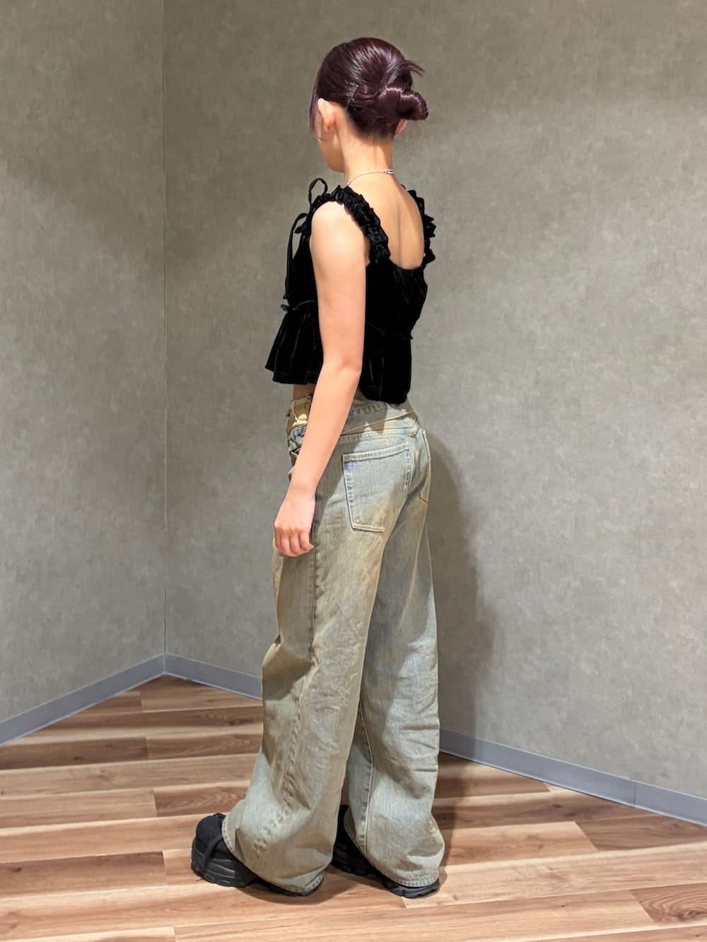 ブラック系のタンクトップ、ブラウン系のデニムパンツ、ブラック系のスニーカーを着用したレディースの夏コーディネートの2枚目の写真