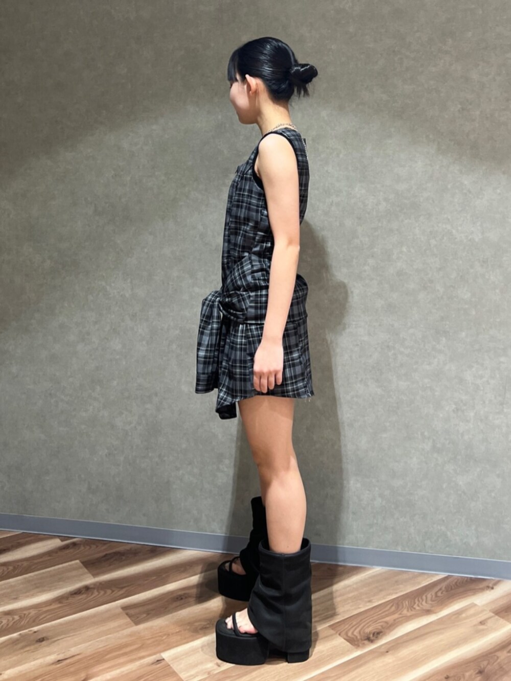 グレー系のワンピース、ブラック系のサンダル、シルバー系のピアス（両耳用）を着用したレディースの夏コーディネートの2枚目の写真