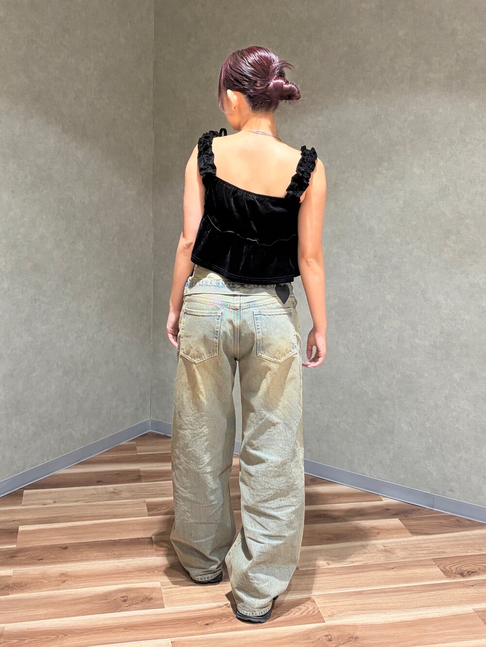 ブラック系のタンクトップ、ブラウン系のデニムパンツ、ブラック系のスニーカーを着用したレディースの夏コーディネートの3枚目の写真