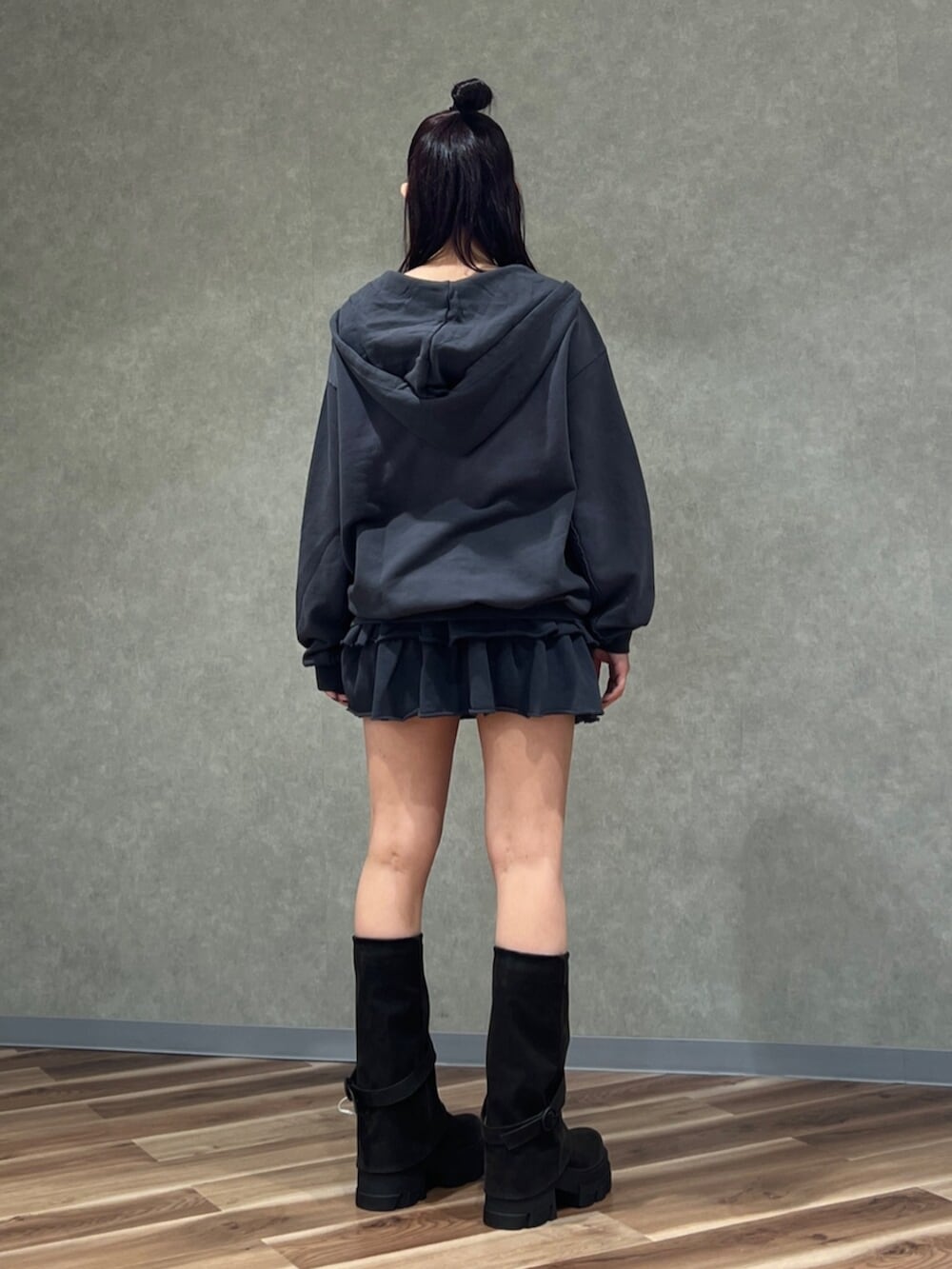 グレー系のスカート、グレー系のパーカー、ブラック系のブーツを着用したレディースの秋コーディネートの3枚目の写真