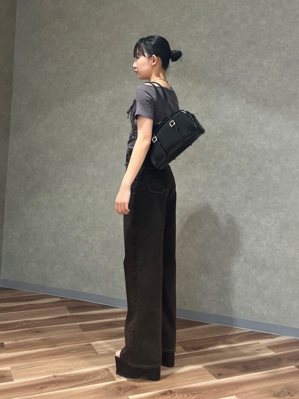 ブラック系のサンダル、ブルー系のデニムパンツ、グレー系のTシャツ/カットソーを着用したレディースの春コーディネートの2枚目の写真