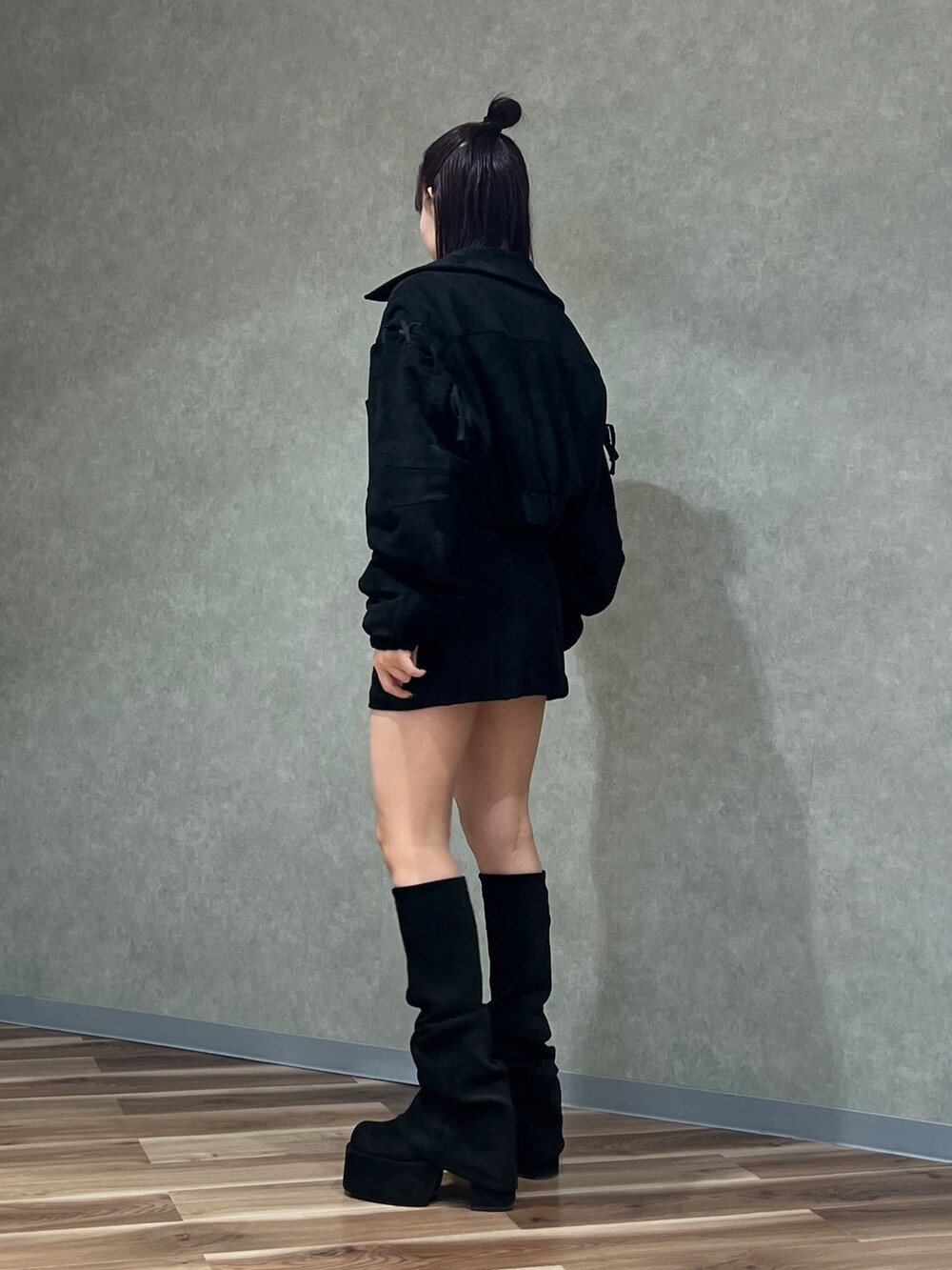 ブラック系のブルゾン、ブラック系のスカート、ホワイト系のTシャツ/カットソーを着用したレディースの秋コーディネートの2枚目の写真