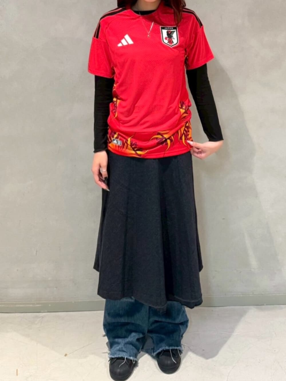 ブラック系のスニーカー、レッド系のトップスを着用したレディースの冬コーディネートの2枚目の写真