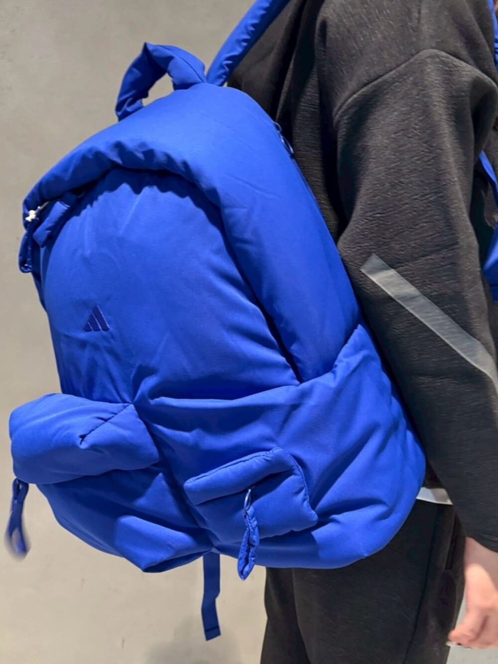 ブラック系のパーカー、ブラック系のパンツ、ブルー系のバックパック/リュックを着用したレディースの冬コーディネートの2枚目の写真