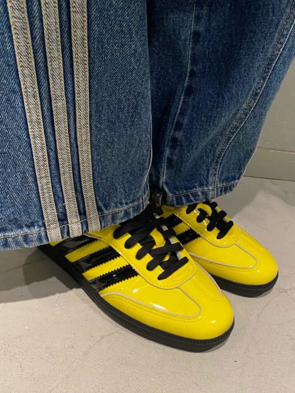 イエロー系のスニーカー、ブルー系のデニムパンツ、ホワイト系のニット/セーターを着用したレディースの秋コーディネートの2枚目の写真