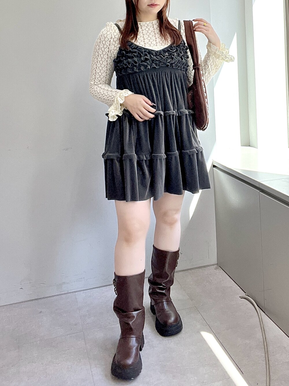 グレー系のワンピース、ホワイト系のTシャツ/カットソー、ブラウン系のブーツを着用したレディースの秋コーディネートの4枚目の写真