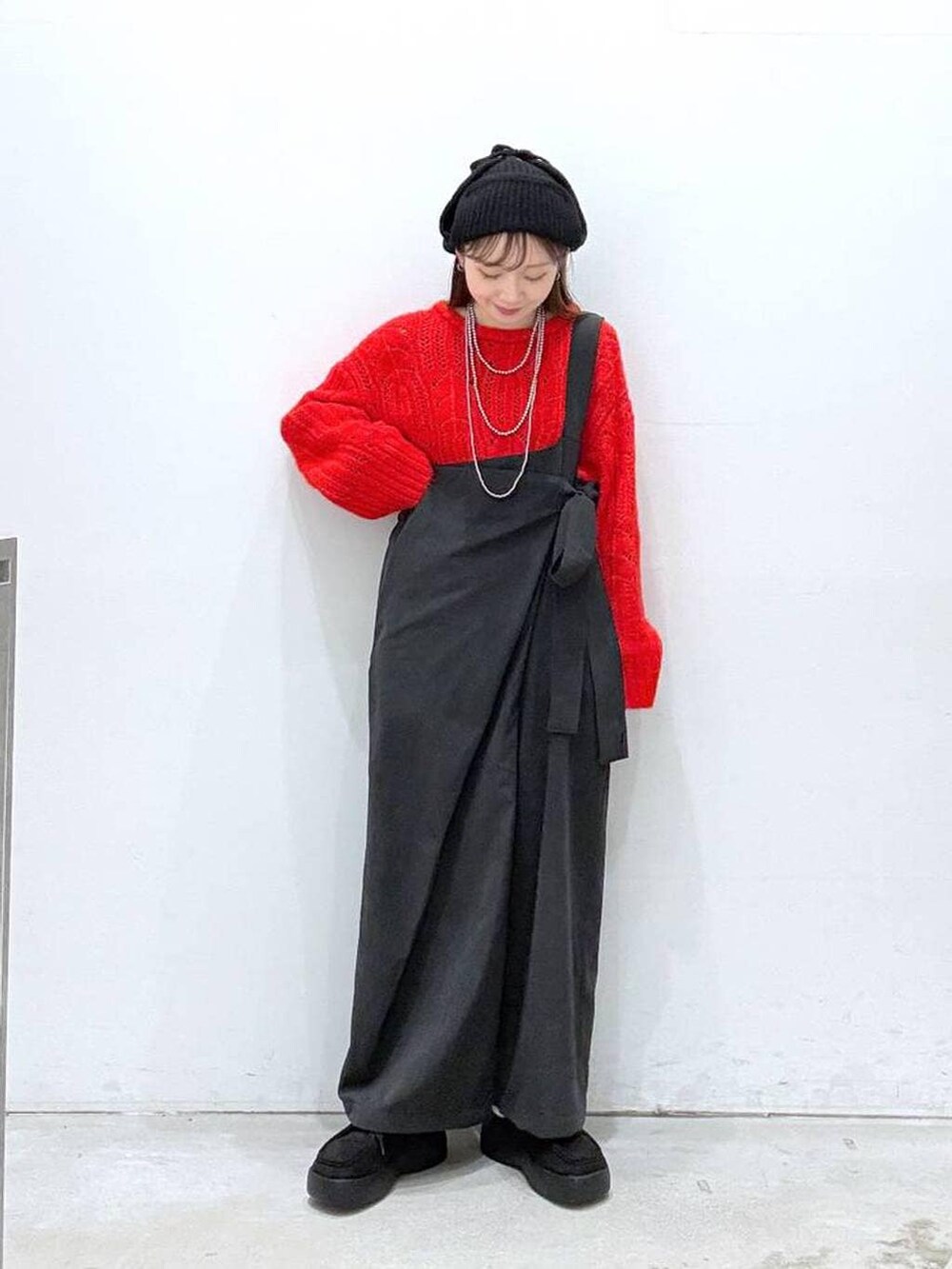 ブラック系のつなぎ/オールインワン、ブラック系のその他シューズ、レッド系のニット/セーターを着用したレディースの冬コーディネートの4枚目の写真