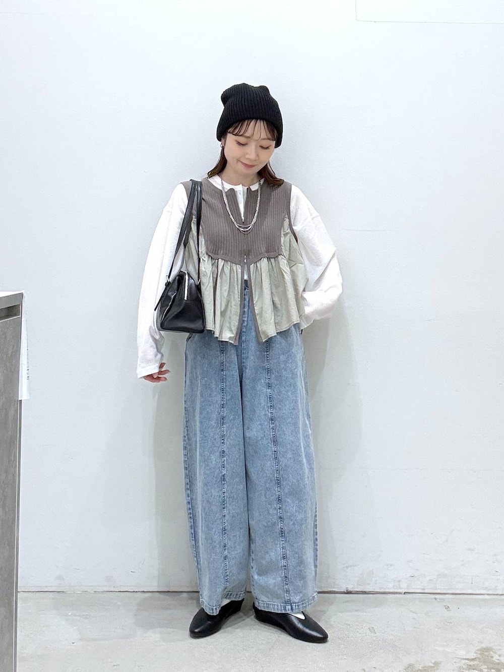 ブラック系のボストンバッグ、ホワイト系のTシャツ/カットソー、ブラック系のパンプスを着用したレディースの春コーディネートの4枚目の写真