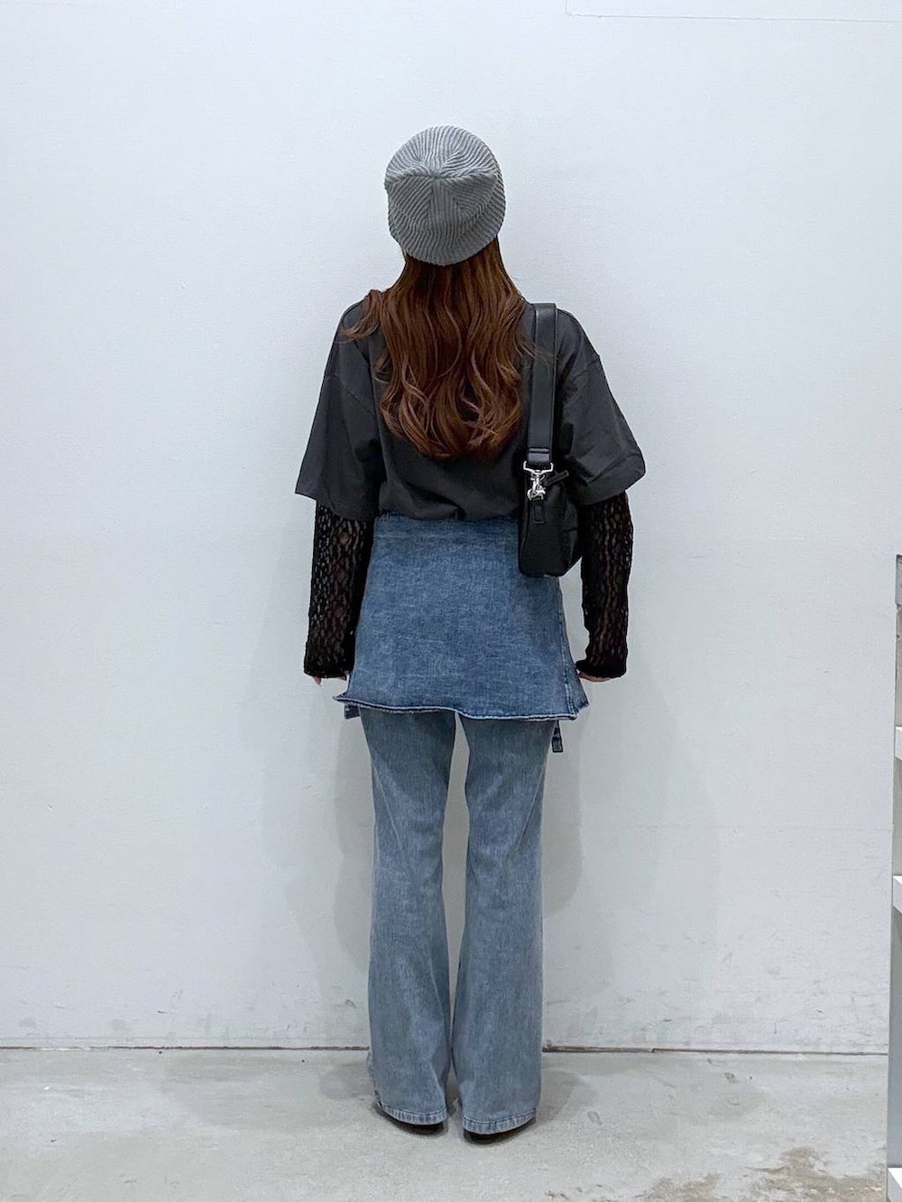 ブルー系のデニムパンツ、グレー系のTシャツ/カットソー、ブラック系のショルダーバッグを着用したレディースの春コーディネートの3枚目の写真