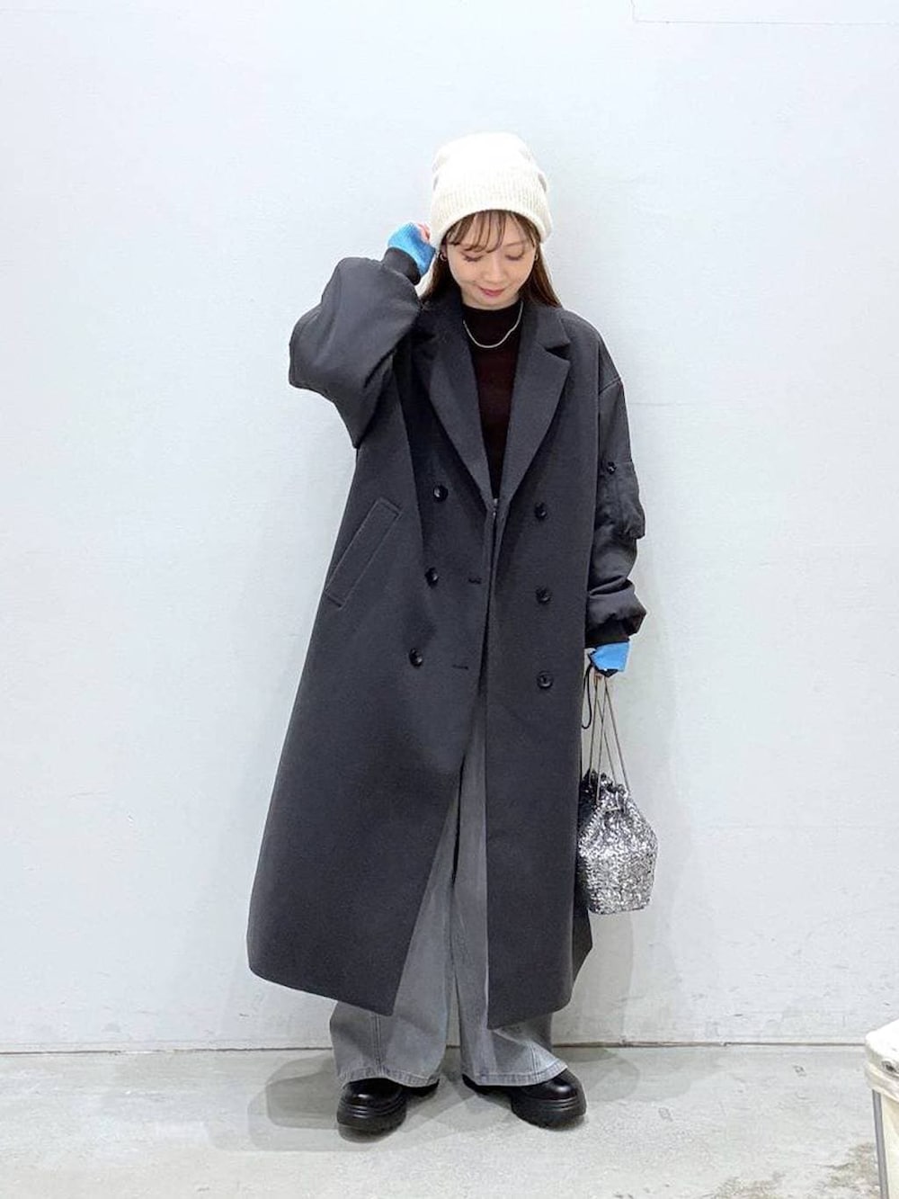 ブラウン系のニット/セーター、ブラック系のブーツ、シルバー系のショルダーバッグを着用したレディースの冬コーディネートの3枚目の写真