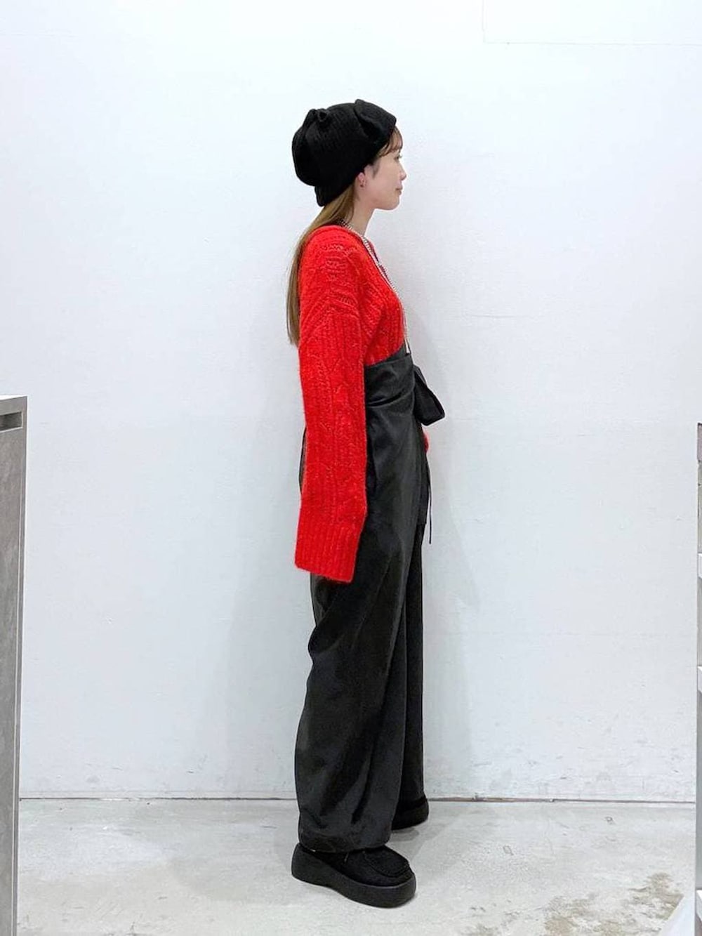 ブラック系のつなぎ/オールインワン、ブラック系のその他シューズ、レッド系のニット/セーターを着用したレディースの冬コーディネートの2枚目の写真