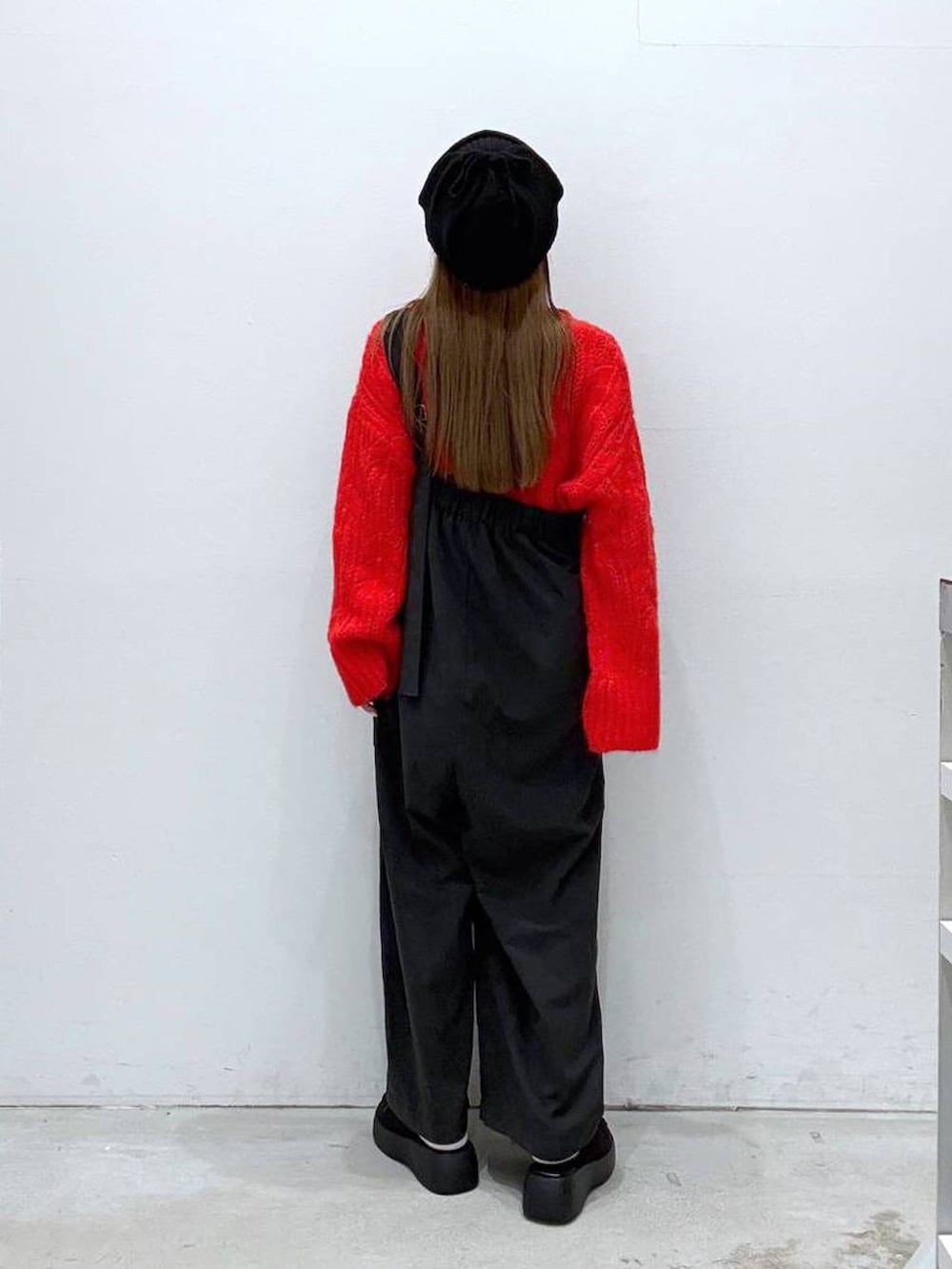 ブラック系のつなぎ/オールインワン、ブラック系のその他シューズ、レッド系のニット/セーターを着用したレディースの冬コーディネートの3枚目の写真