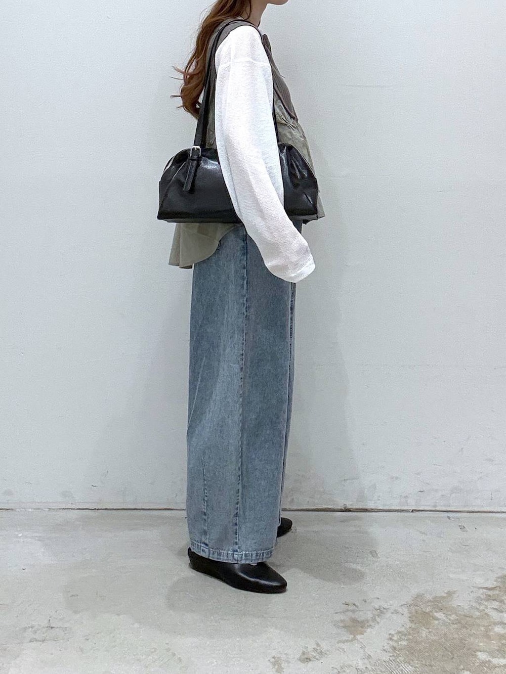 ブラック系のボストンバッグ、ホワイト系のTシャツ/カットソー、ブラック系のパンプスを着用したレディースの春コーディネートの2枚目の写真