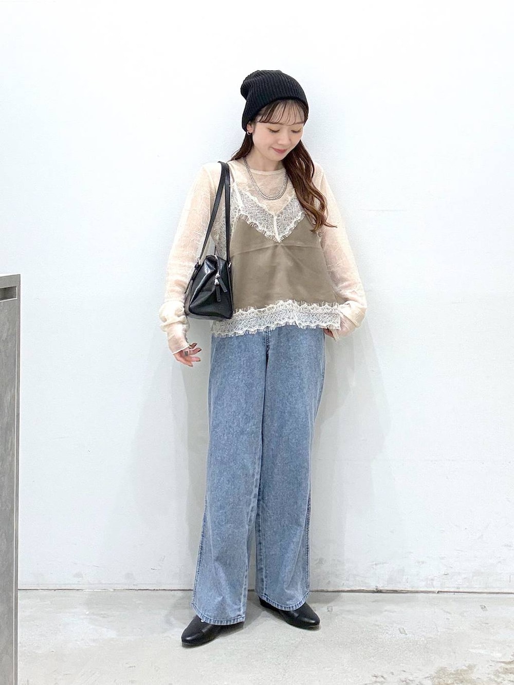 ブラック系のボストンバッグ、ブルー系のデニムパンツ、ブラック系のパンプスを着用したレディースの春コーディネートの4枚目の写真