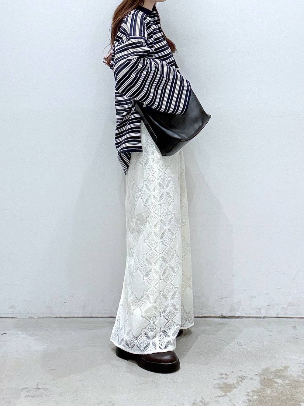 ホワイト系のTシャツ/カットソー、ブラック系のショルダーバッグ、ブラウン系のサンダルを着用したレディースの冬コーディネートの2枚目の写真