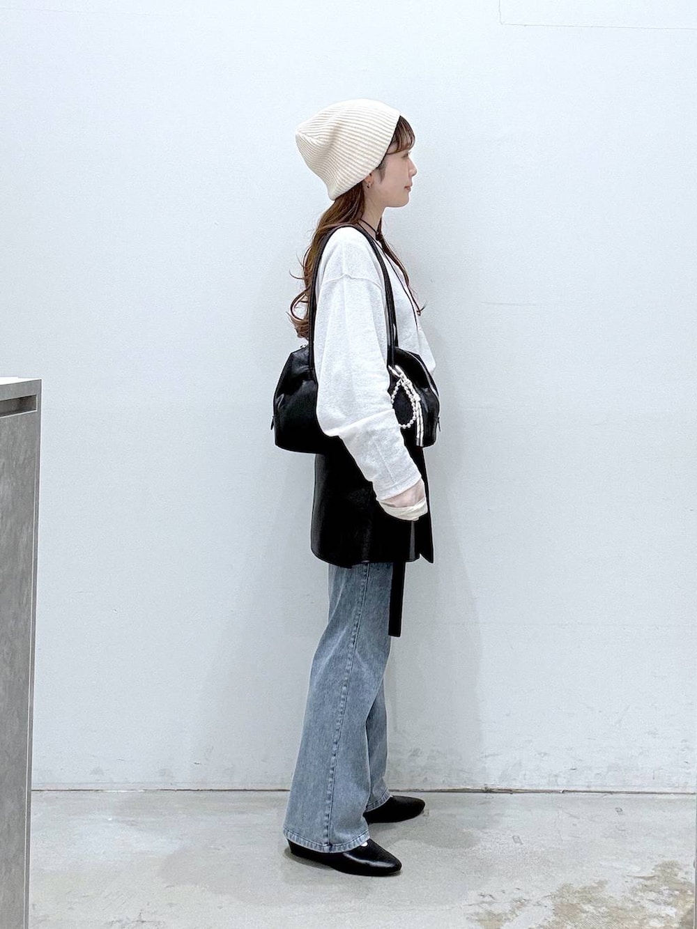 ホワイト系のTシャツ/カットソー、ブラック系のボストンバッグ、ブルー系のデニムパンツを着用したレディースの春コーディネートの2枚目の写真