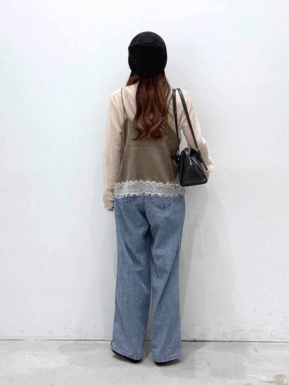 ブラック系のボストンバッグ、ブルー系のデニムパンツ、ブラック系のパンプスを着用したレディースの春コーディネートの3枚目の写真