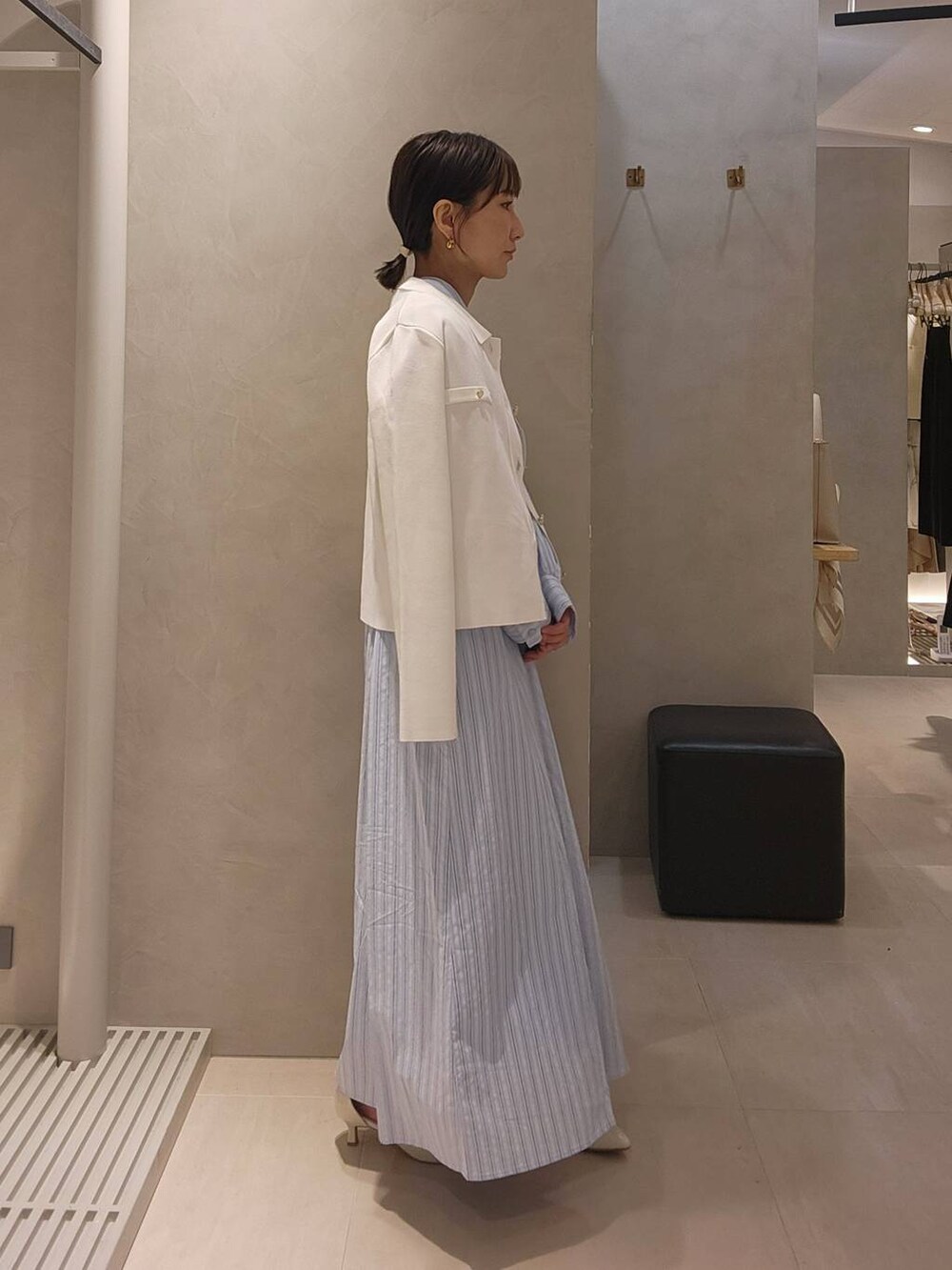 ホワイト系のパンプス、ホワイト系のニット/セーター、ブルー系のワンピースを着用したレディースの春コーディネートの4枚目の写真