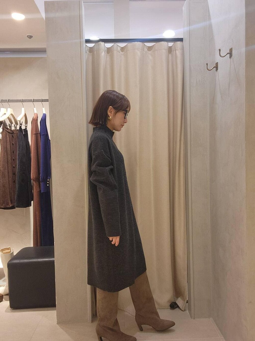 グレー系のチュニック、ベージュ系のブーツ、ブラック系のメガネを着用したレディースの秋コーディネートの3枚目の写真