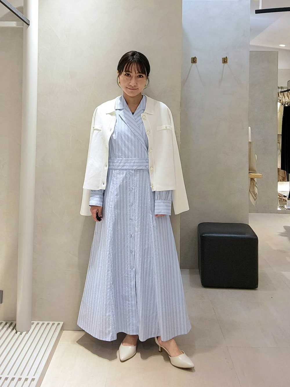 ホワイト系のパンプス、ホワイト系のニット/セーター、ブルー系のワンピースを着用したレディースの春コーディネートの2枚目の写真