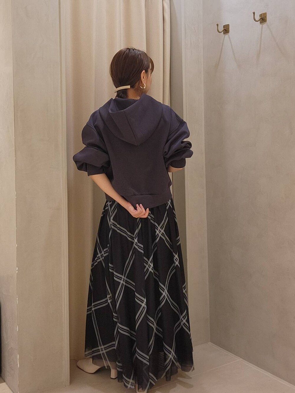 ホワイト系のブーツ、グレー系のパーカー、ブルー系のスカートを着用したレディースの秋コーディネートの3枚目の写真