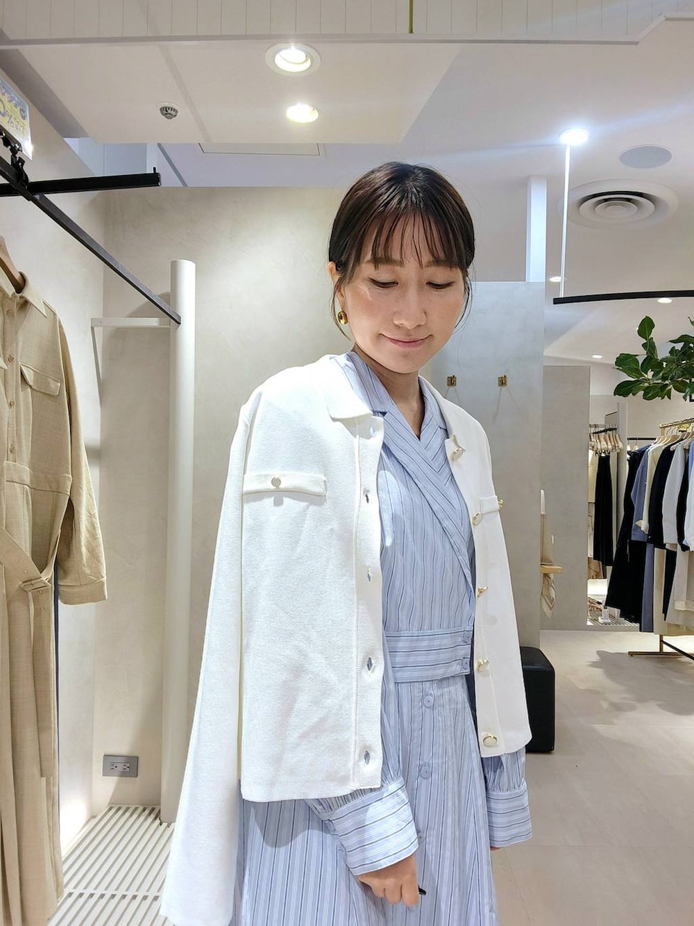 ホワイト系のパンプス、ホワイト系のニット/セーター、ブルー系のワンピースを着用したレディースの春コーディネートの3枚目の写真