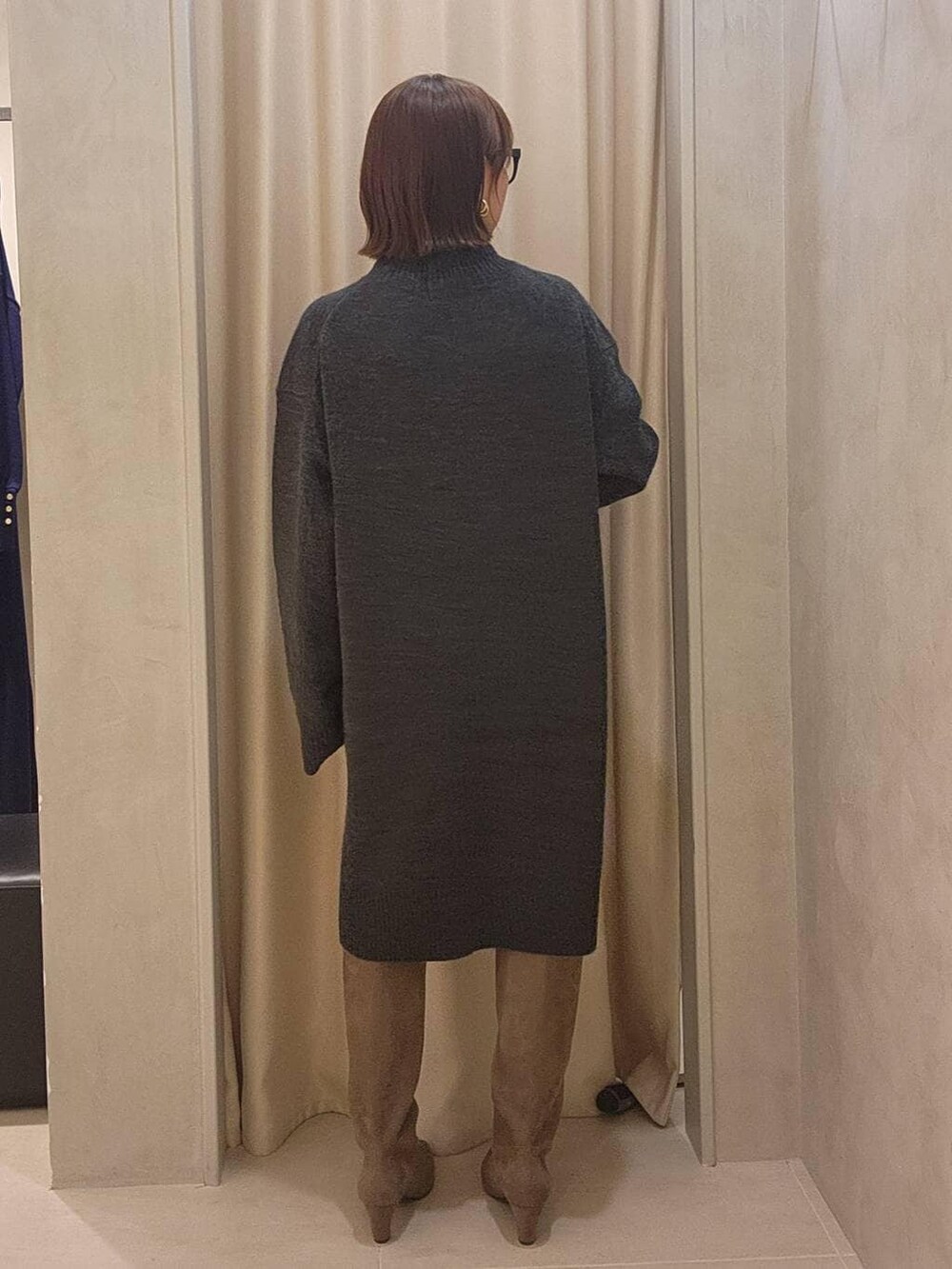 グレー系のチュニック、ベージュ系のブーツ、ブラック系のメガネを着用したレディースの秋コーディネートの4枚目の写真