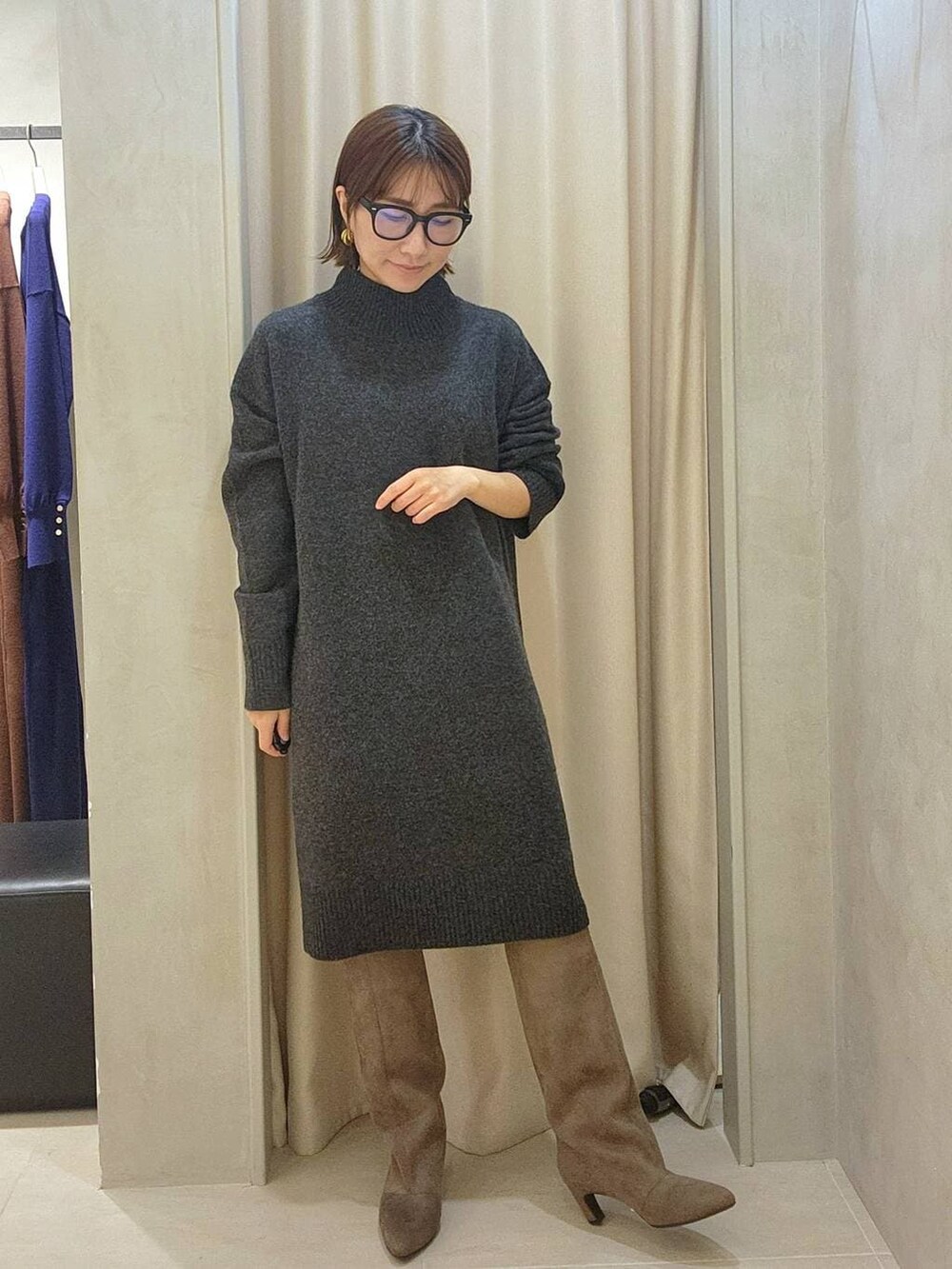 グレー系のチュニック、ベージュ系のブーツ、ブラック系のメガネを着用したレディースの秋コーディネートの5枚目の写真