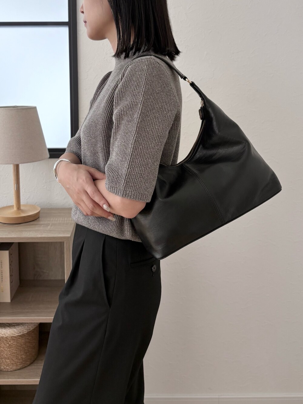 ブラック系のショルダーバッグ、グレー系のニット/セーターを着用したレディースの夏コーディネートの2枚目の写真