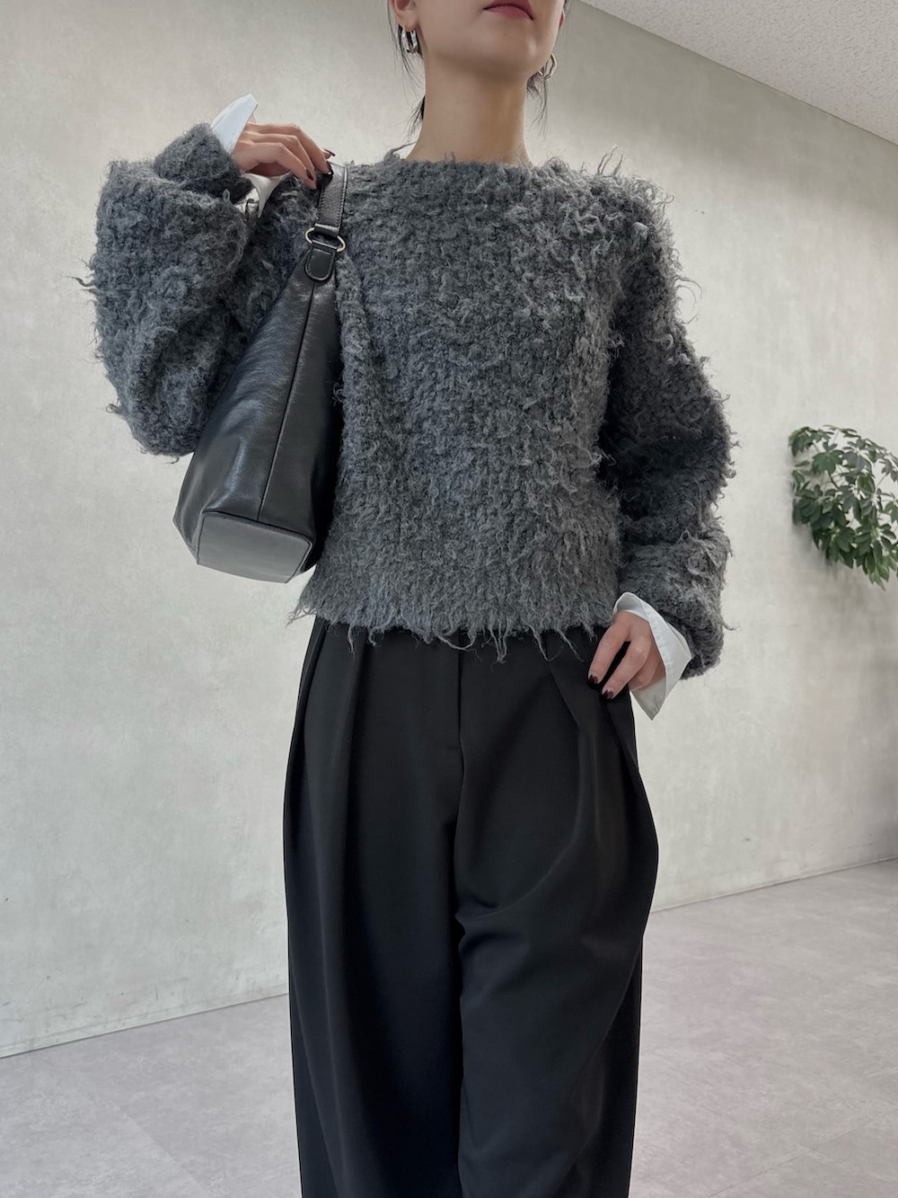 ブラック系のその他パンツ、グレー系のニット/セーター、ブラック系のショルダーバッグを着用したレディースの冬コーディネートの3枚目の写真