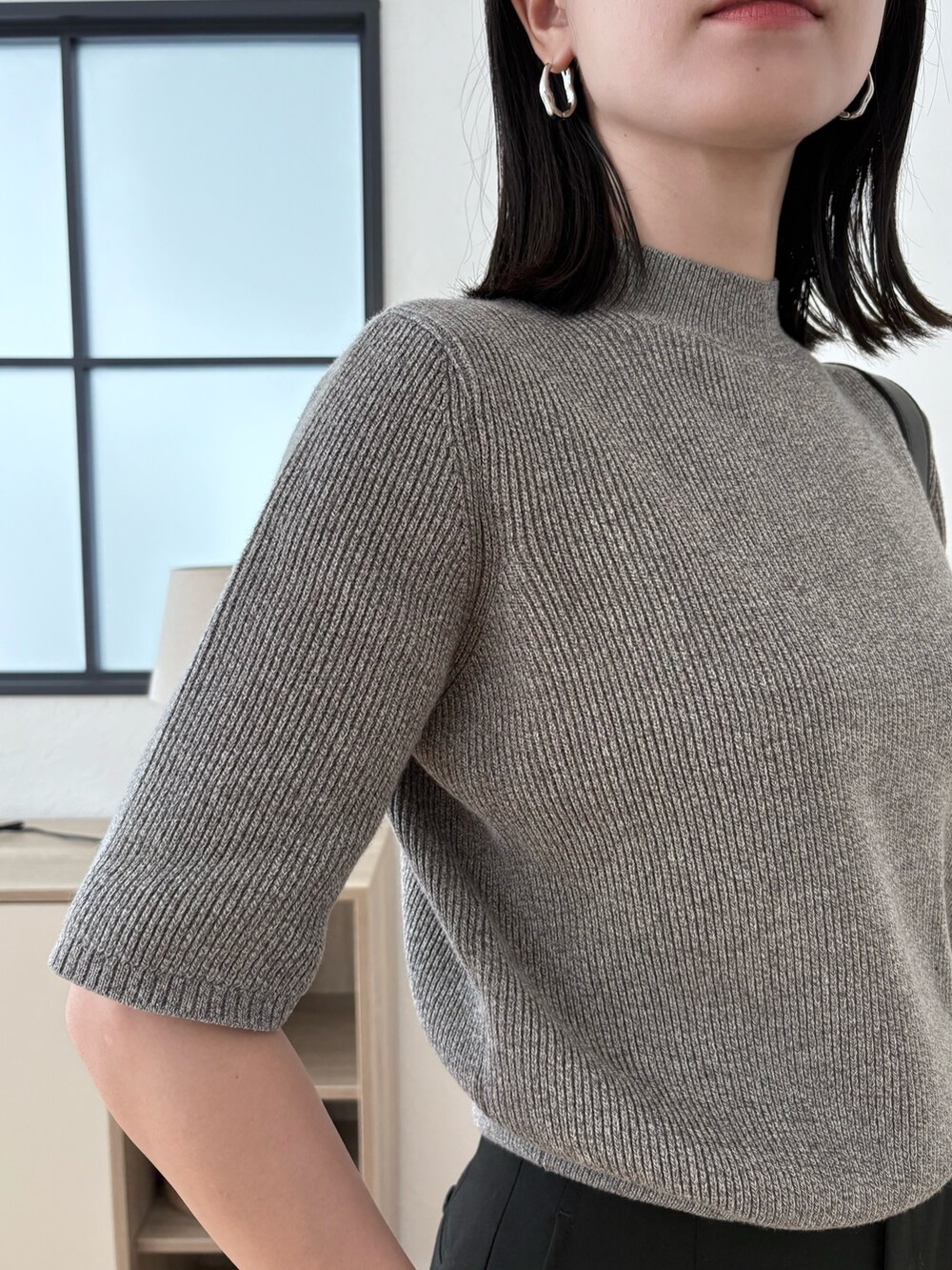 ブラック系のショルダーバッグ、グレー系のニット/セーターを着用したレディースの夏コーディネートの3枚目の写真