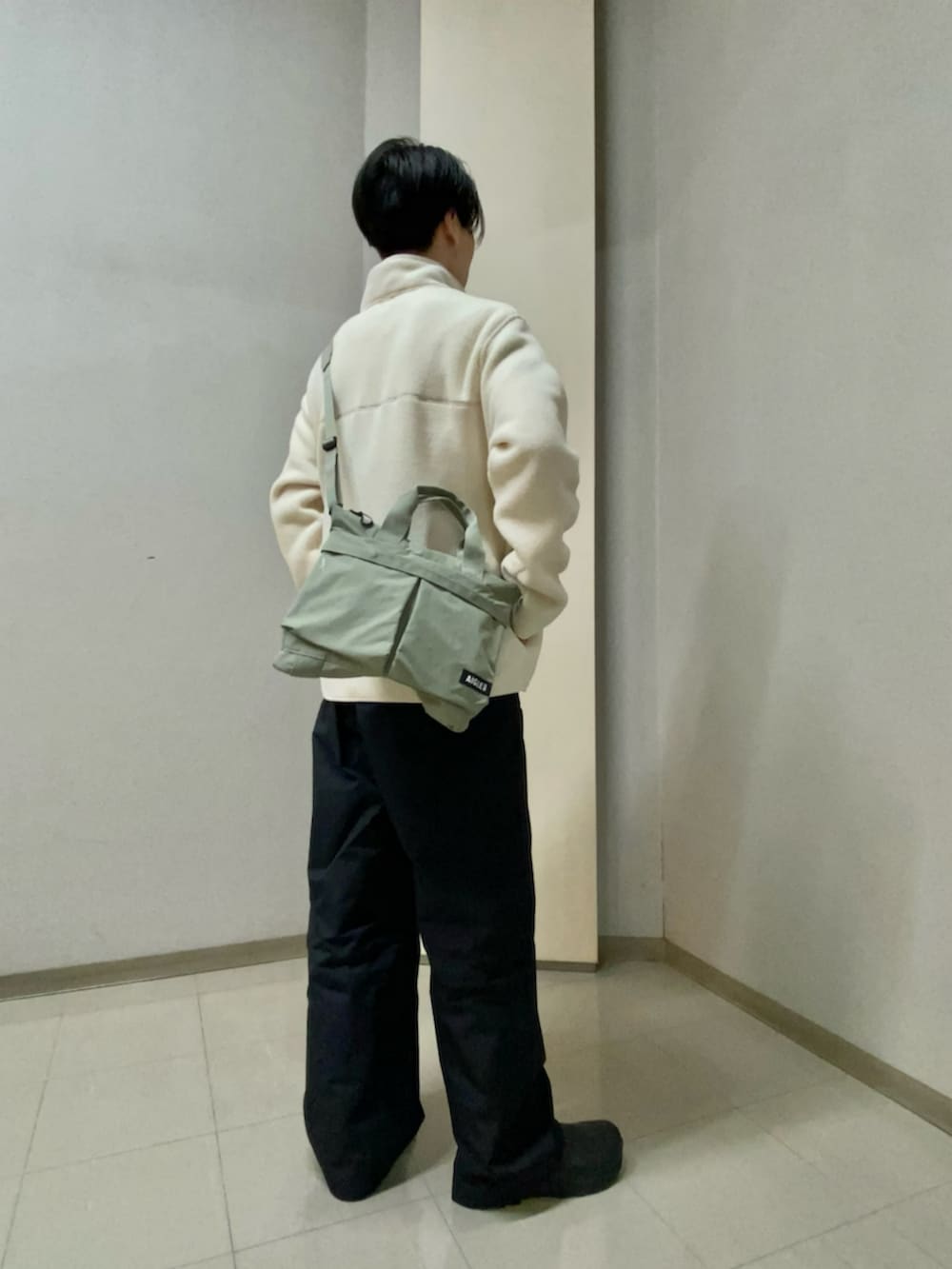グリーン系のトートバッグを着用したメンズの冬コーディネートの3枚目の写真