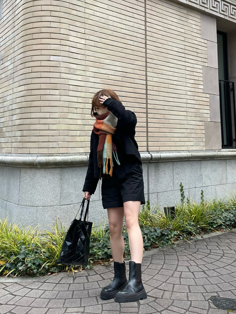 ブラック系のトートバッグ、ブラック系のその他パンツ、ブラック系のブーツを着用したレディースの冬コーディネートの2枚目の写真