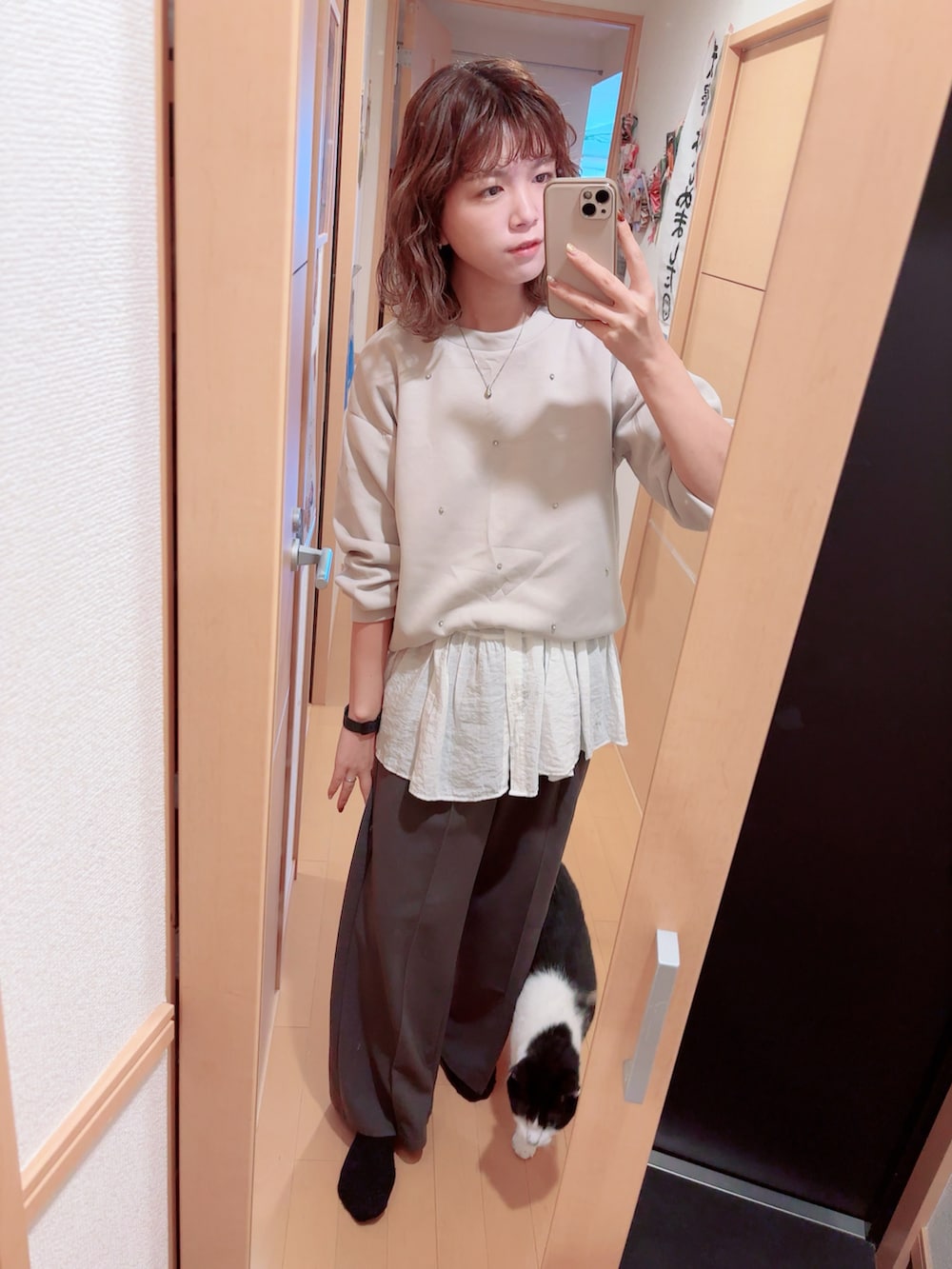 グレー系のスウェット、ホワイト系のシャツ/ブラウス、グレー系のスラックスを着用したレディースの秋コーディネートの2枚目の写真