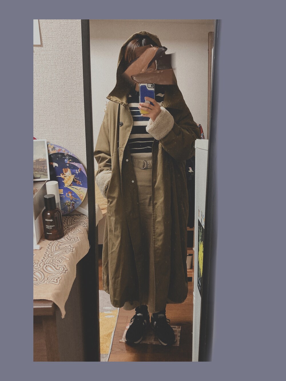 ブルー系のニット/セーター、ベージュ系のスカート、ブラック系のスニーカーを着用したレディースの冬コーディネートの2枚目の写真