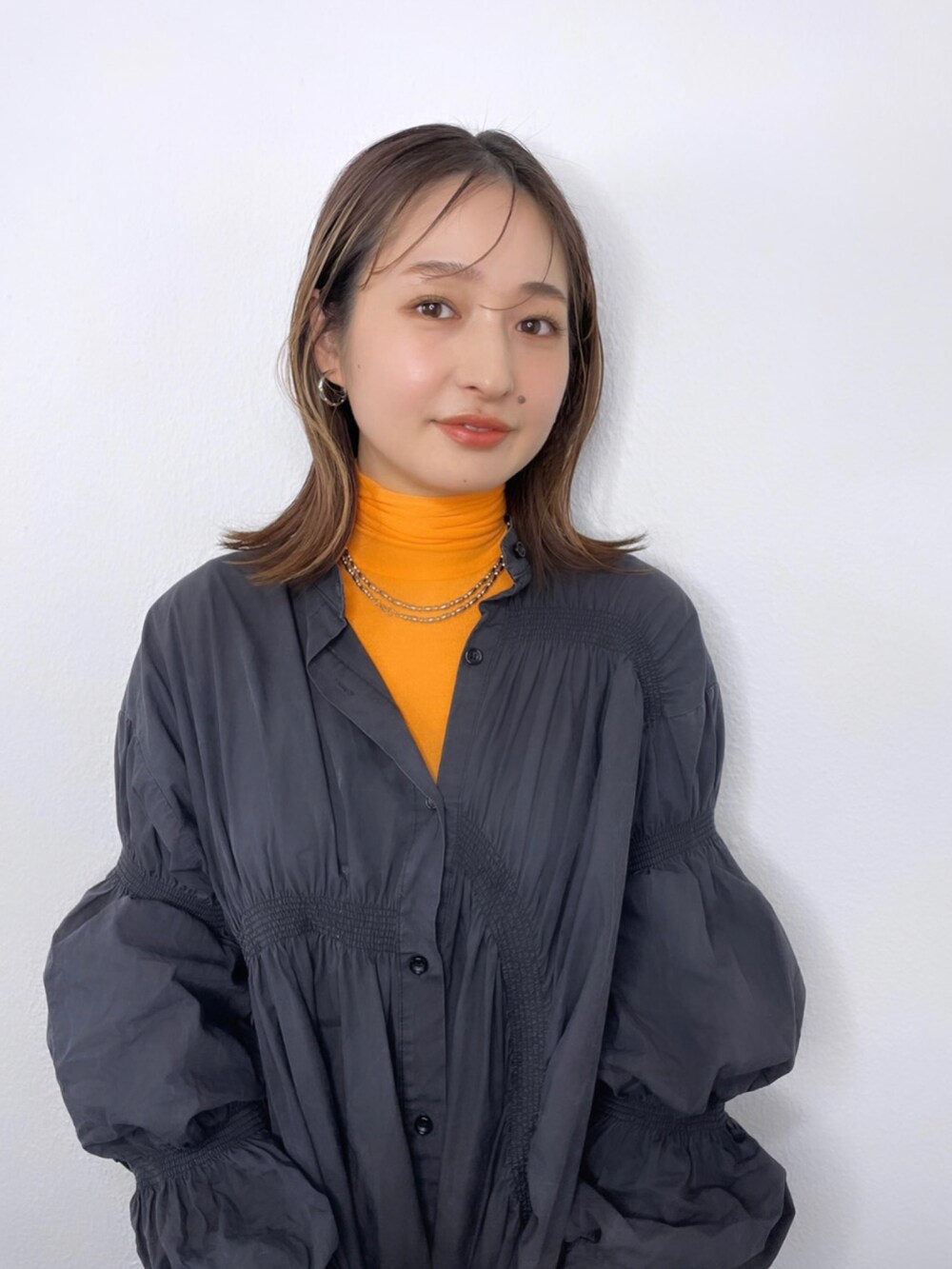 オレンジ系のその他トップスを着用したレディースの冬コーディネートの2枚目の写真