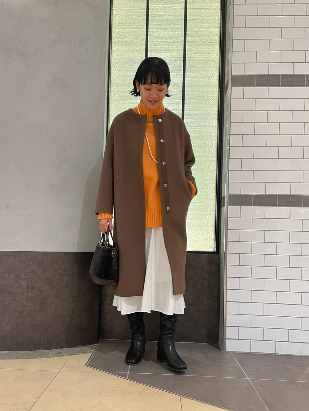 「オレンジニット、冬コーデ、コート、NOLLEY'S、ノーリーズ、ブラウンコート、ウールコート、ロングコート、ハイネックニット、白スカート、ロングブーツ、大人カジュアル」｜「NOLLEY’Sのコットンパールネックレス 100cm（ネックレス、ホワイト系）」を使った、fukudaさん（レディース・170cm）の冬コーディネートの2枚目の写真