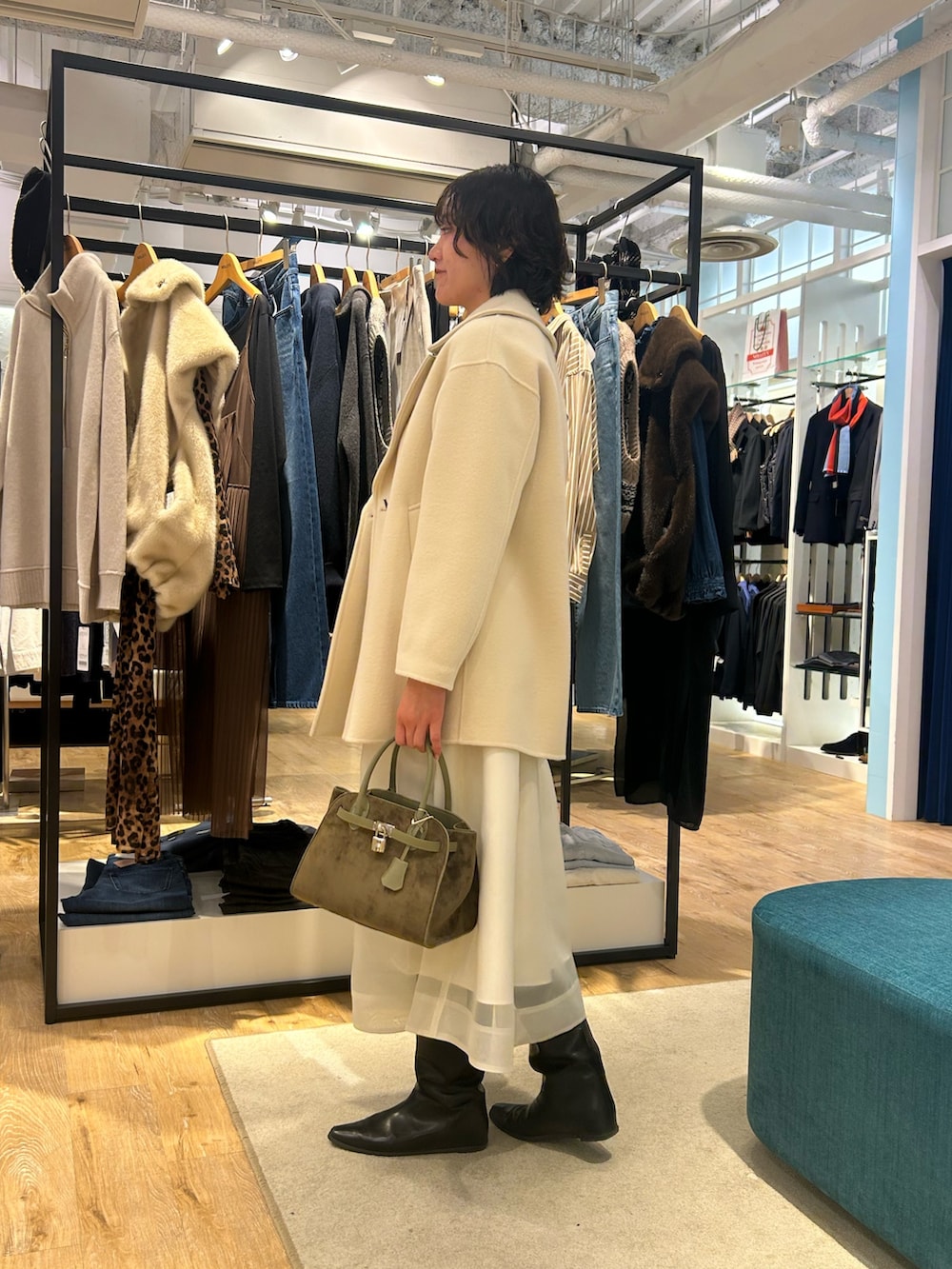 ホワイト系のスカート、イエロー系のニット/セーター、グリーン系のトートバッグを着用したレディースの冬コーディネートの9枚目の写真