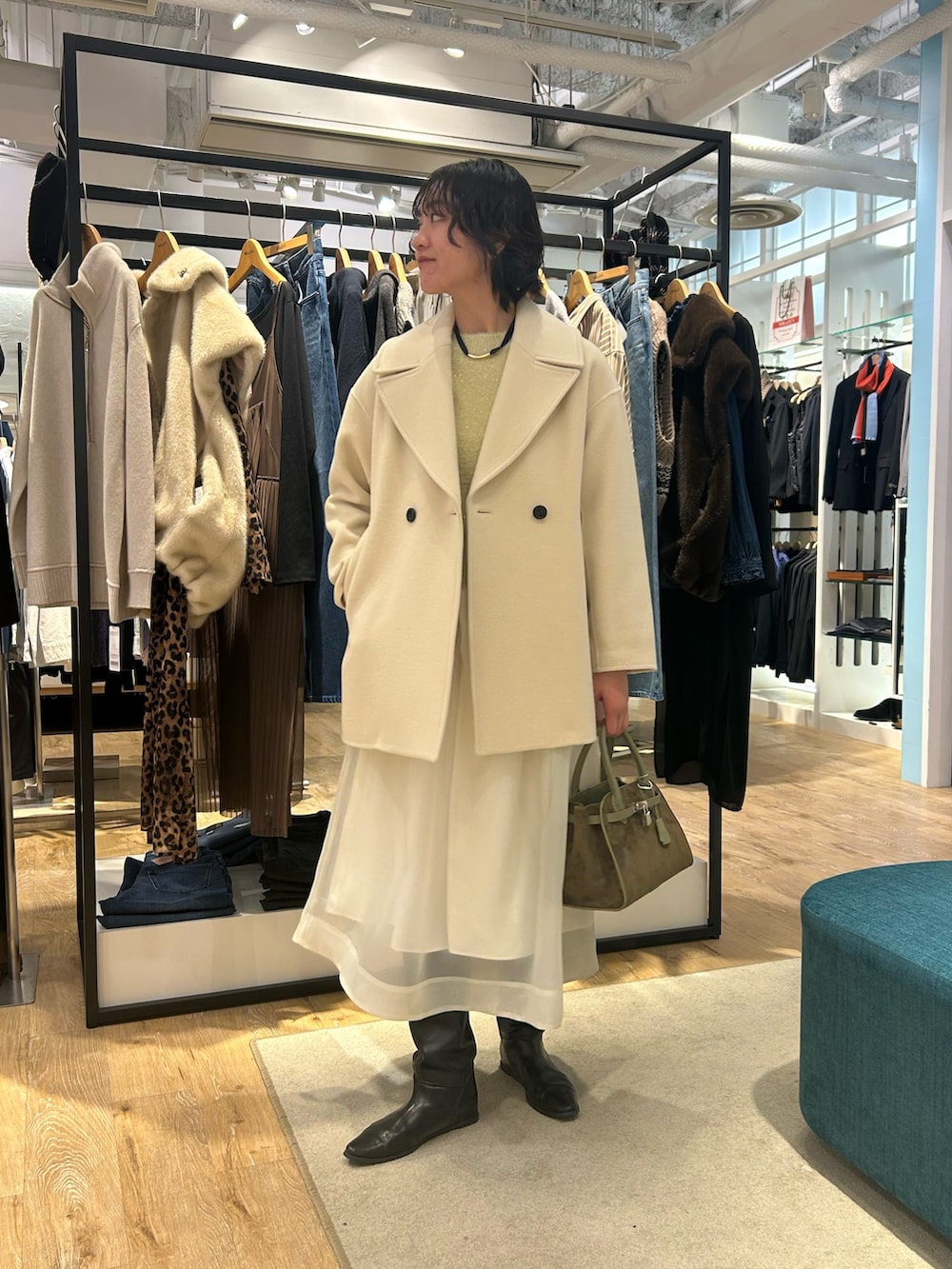 ホワイト系のスカート、イエロー系のニット/セーター、グリーン系のトートバッグを着用したレディースの冬コーディネートの7枚目の写真