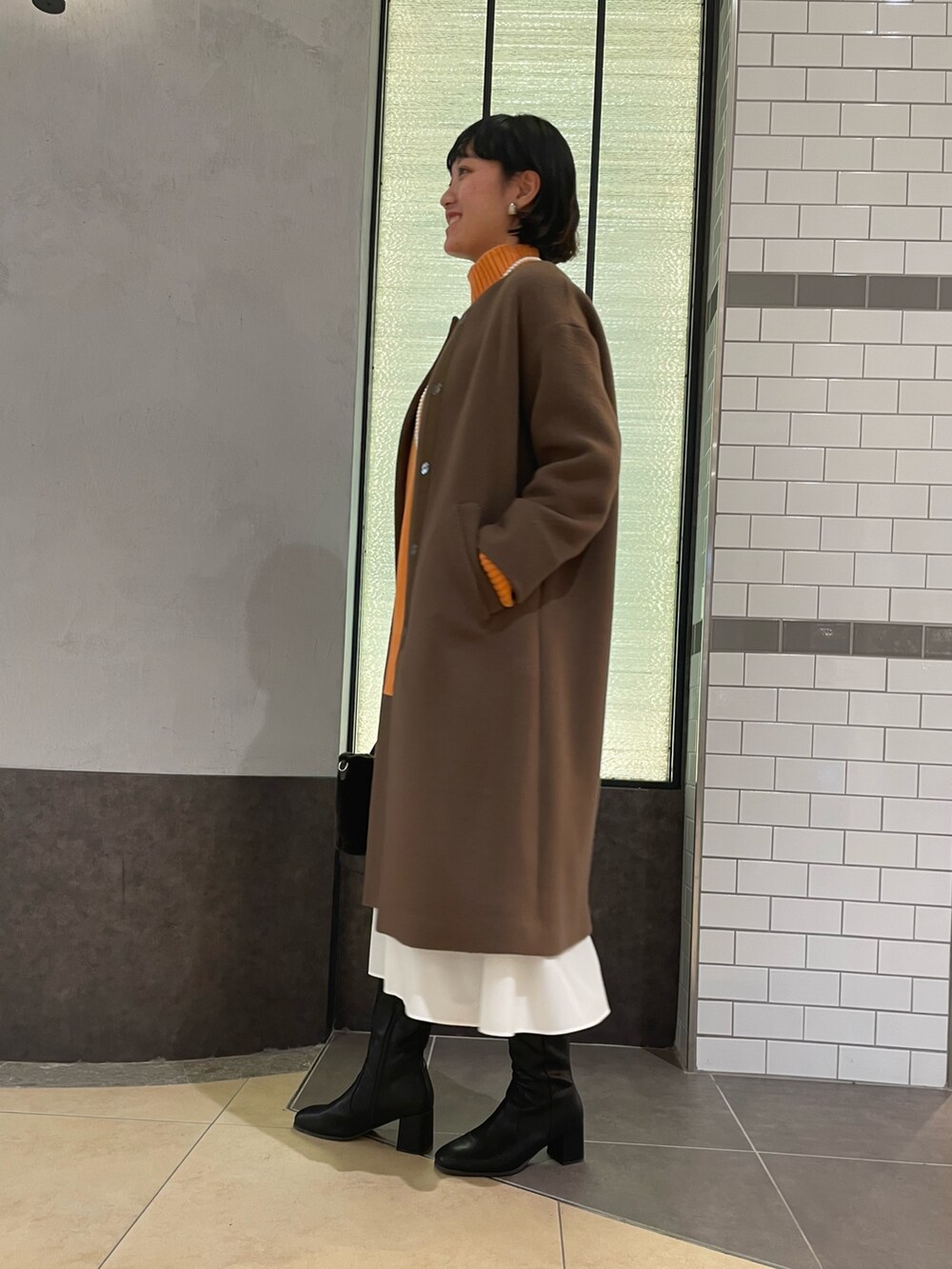 「オレンジニット、冬コーデ、コート、NOLLEY'S、ノーリーズ、ブラウンコート、ウールコート、ロングコート、ハイネックニット、白スカート、ロングブーツ、大人カジュアル」｜「NOLLEY’Sのコットンパールネックレス 100cm（ネックレス、ホワイト系）」を使った、fukudaさん（レディース・170cm）の冬コーディネートの3枚目の写真