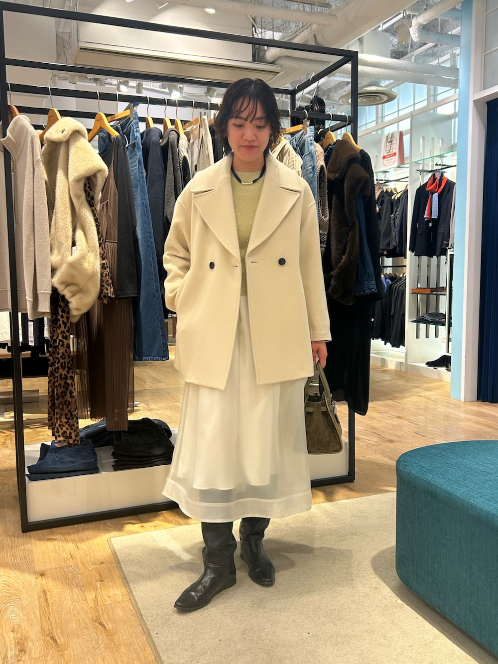 ホワイト系のスカート、イエロー系のニット/セーター、グリーン系のトートバッグを着用したレディースの冬コーディネートの6枚目の写真