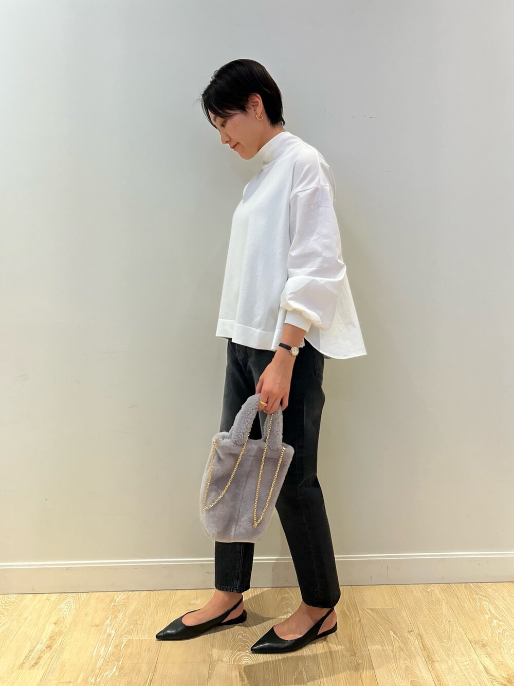 グレー系のトートバッグ、ブラック系のデニムパンツ、ブラック系のベルトを着用したレディースの冬コーディネートの7枚目の写真