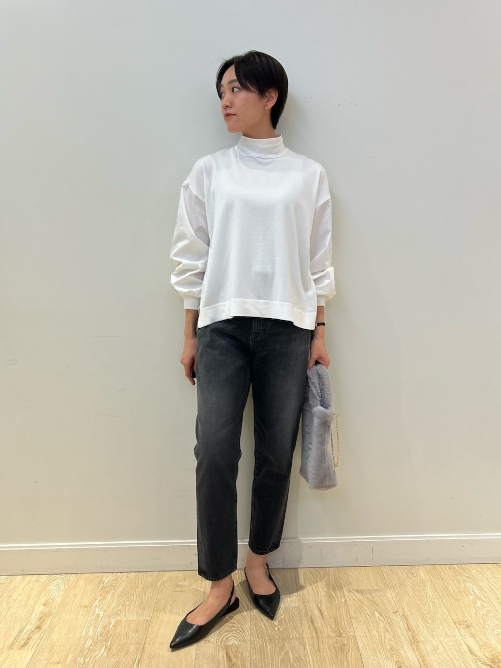 グレー系のトートバッグ、ブラック系のデニムパンツ、ブラック系のベルトを着用したレディースの冬コーディネートの6枚目の写真