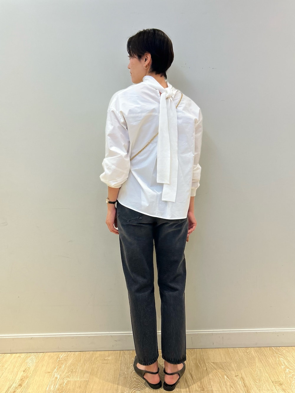 グレー系のトートバッグ、ブラック系のデニムパンツ、ブラック系のベルトを着用したレディースの冬コーディネートの5枚目の写真