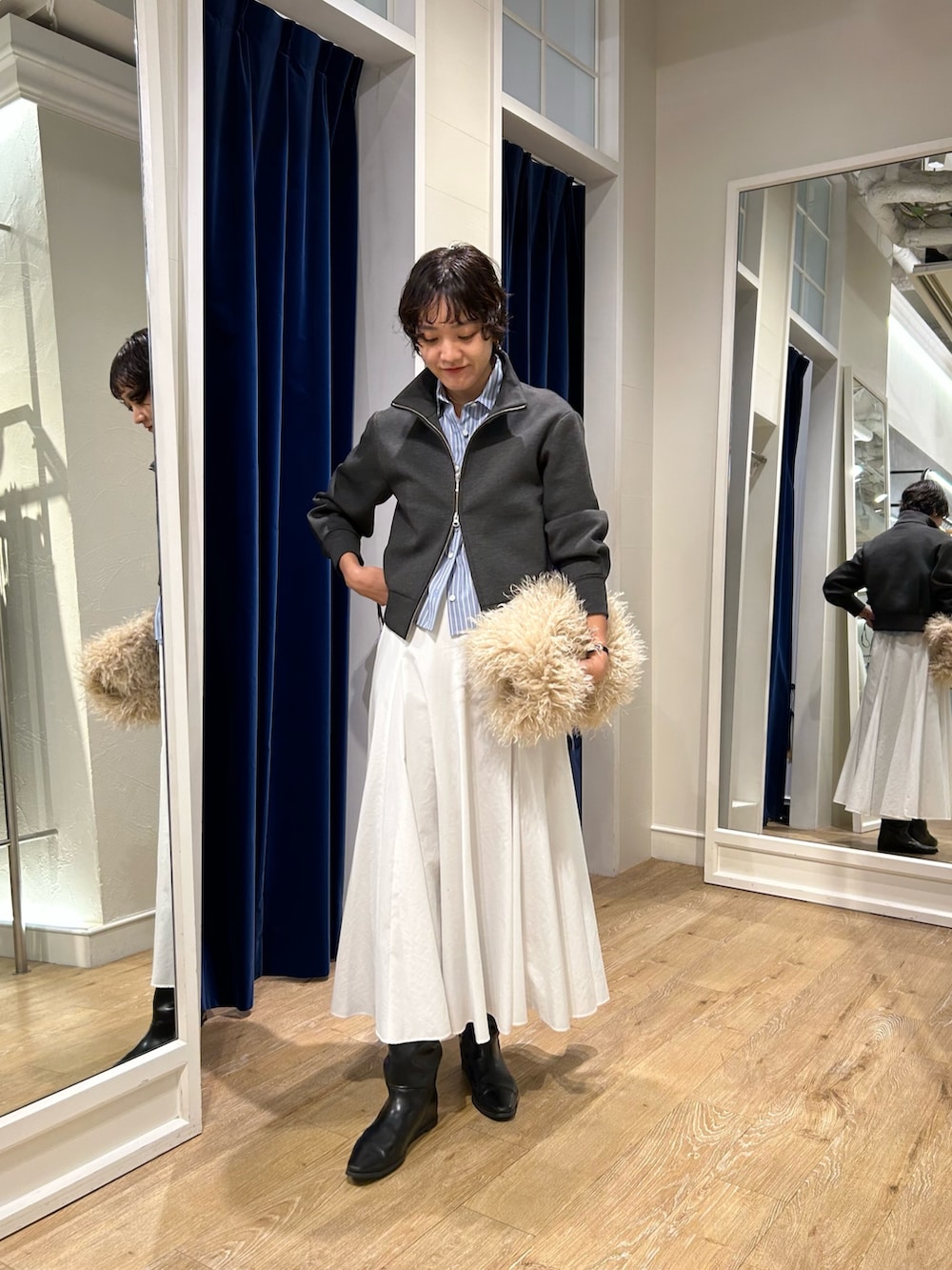 グレー系のブルゾン、ブルー系のシャツ/ブラウス、ホワイト系のスカートを着用したレディースの秋コーディネートの4枚目の写真